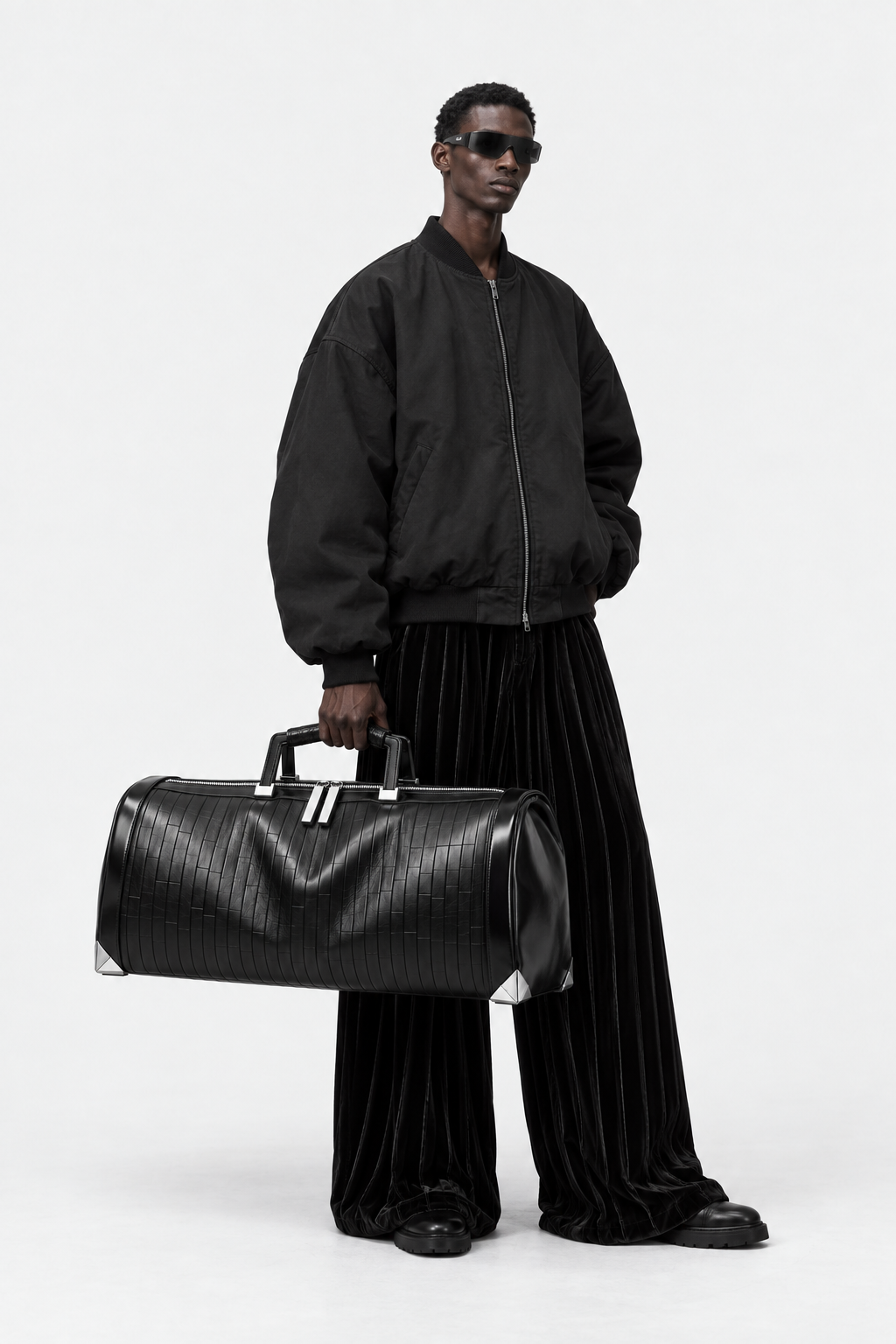 Model carrying the large black Pentagon barrel duffel at his side