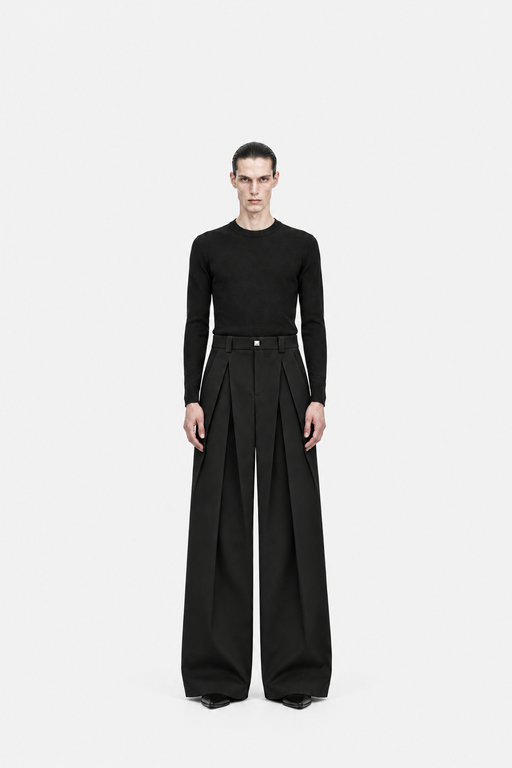 Male model wearing black Octagon double-layer pleated trousers, front fit view