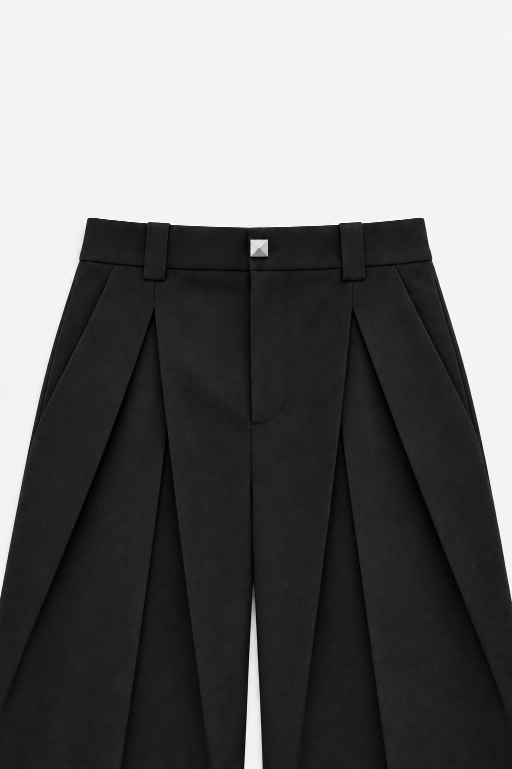 Close view of layered front pleats, wide belt loops, and square button