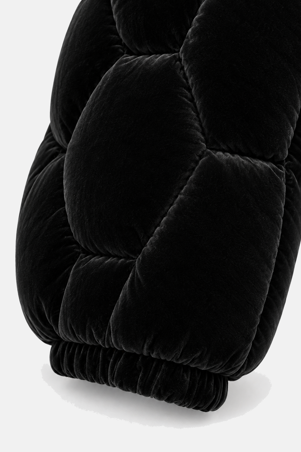 Close detail of the black velvet OCTAGON Pentagon Puffer pile, quilting seams, and elastic cuff