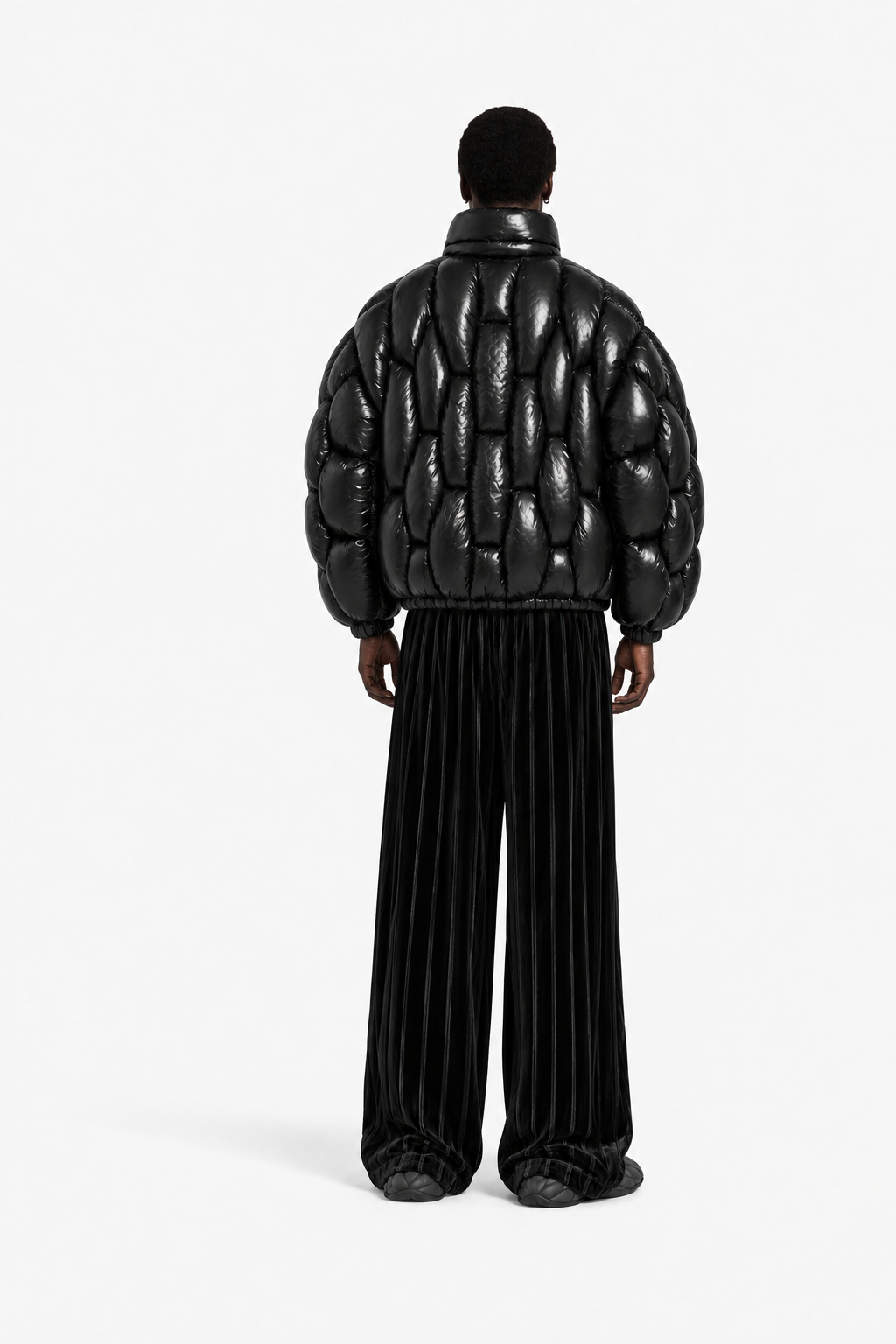 Male model wearing the glossy black OCTAGON Pentagon Puffer in a tag-free back view