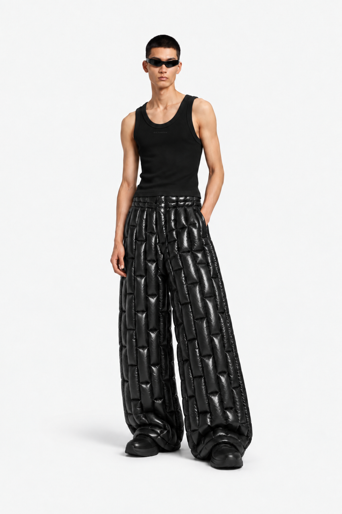 Male model wearing the black OCTAGON knitted rib tank with wide black puffer trousers