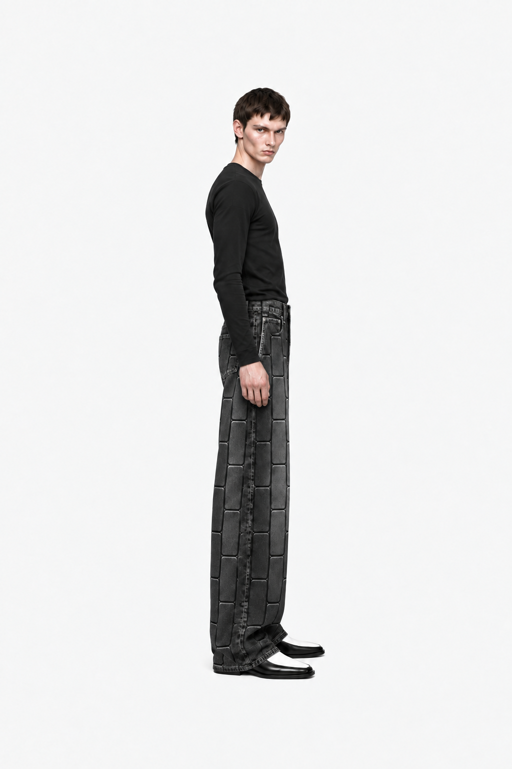 Male model wearing washed-black OCTAGON Pentagon debossed jeans, side profile